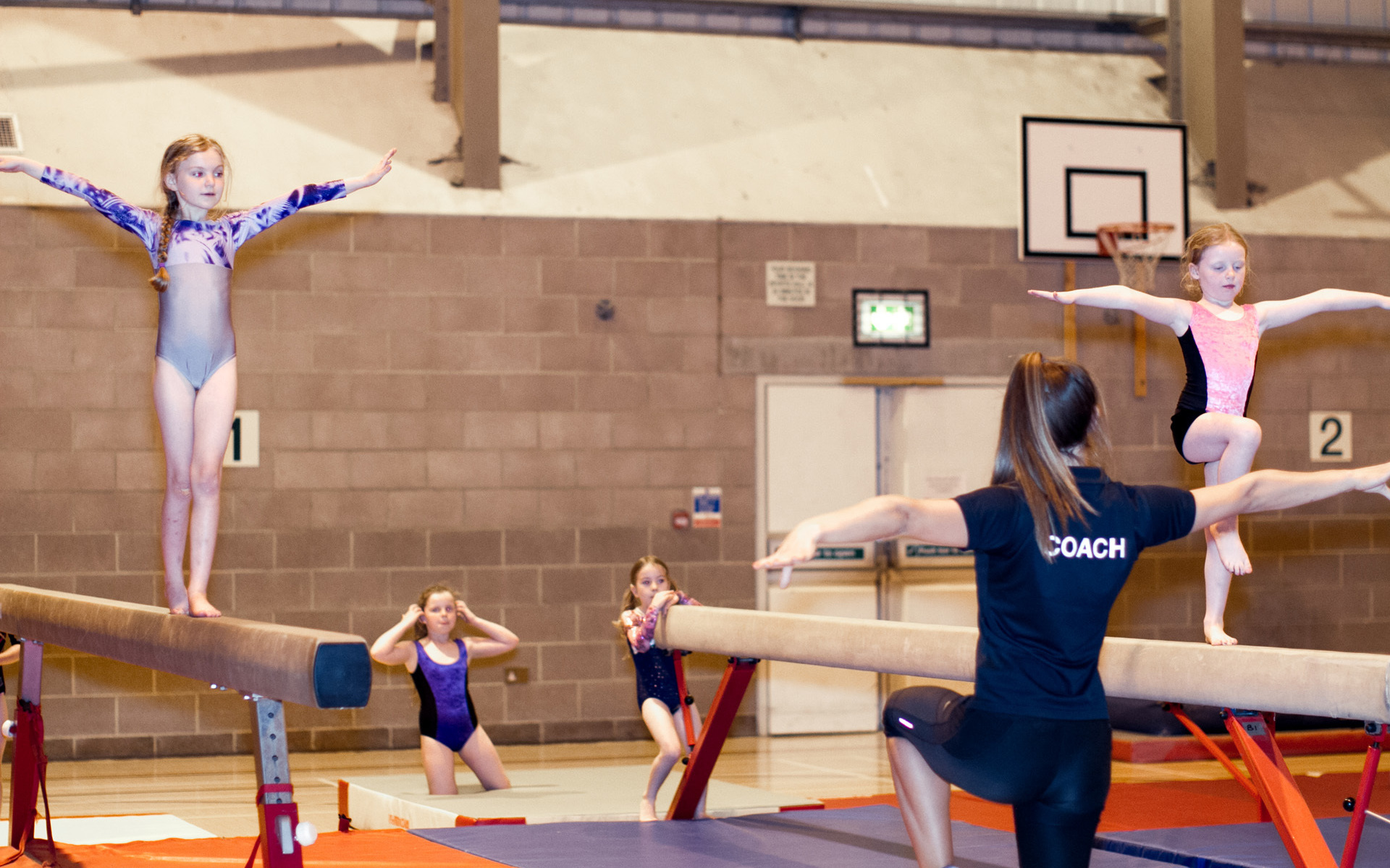 Girls on beam with instructor