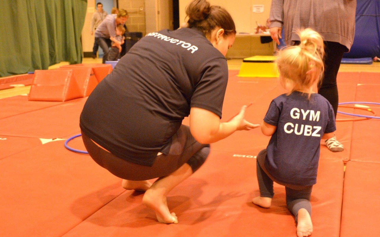 small child gymnast with instructor