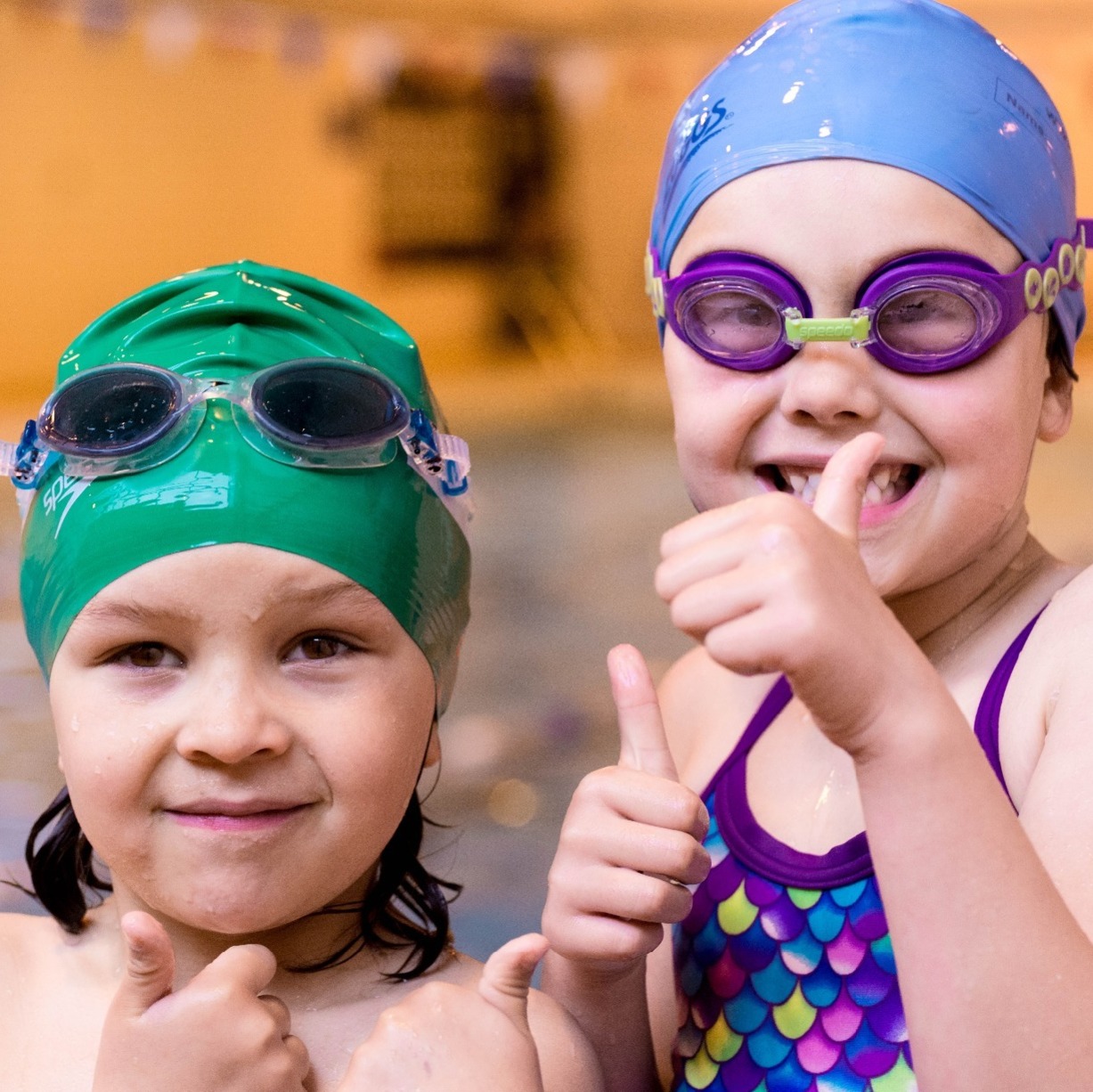 Kids in swimming costumes giving thumbs up