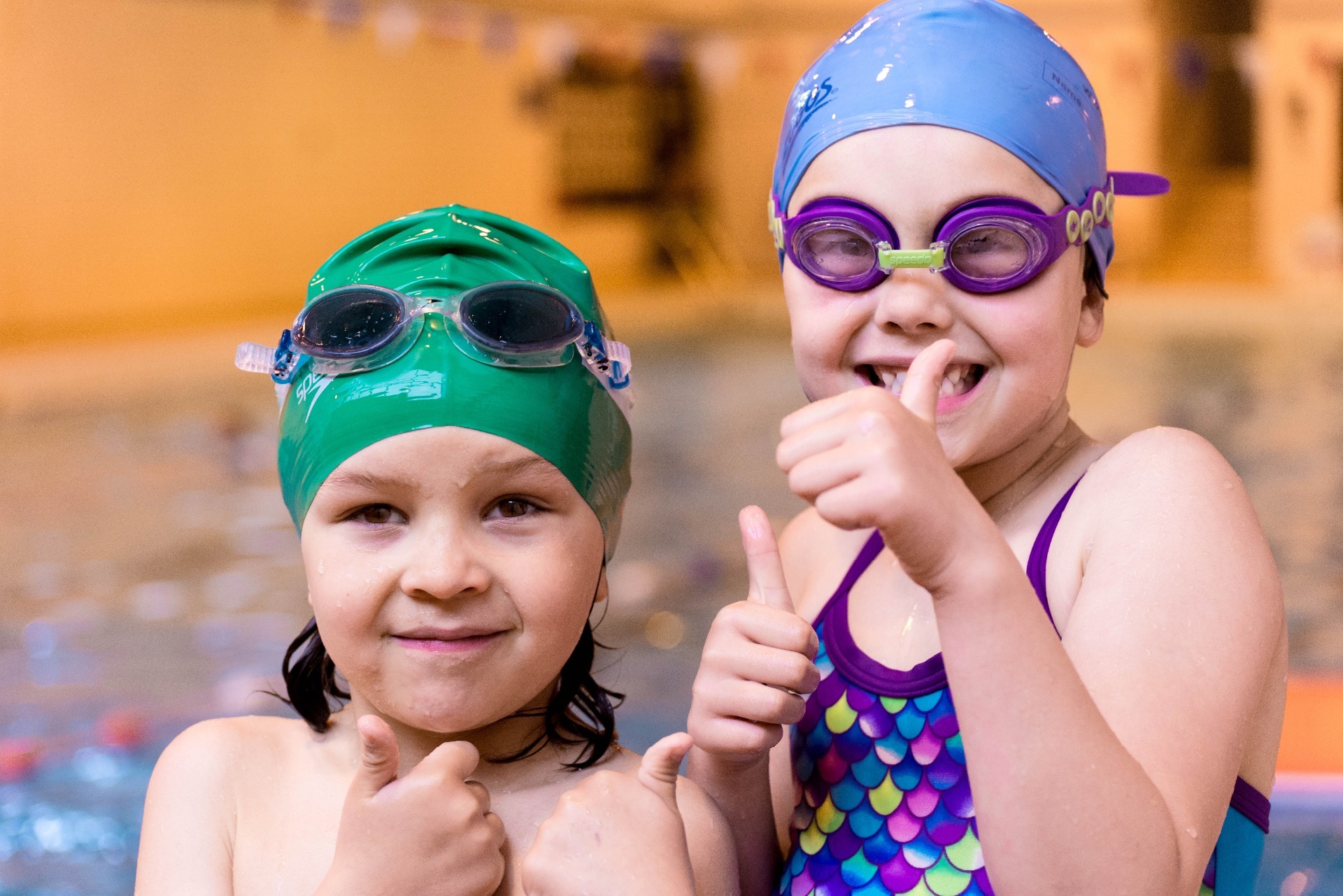 Children in swimming costumes giving thumbs up