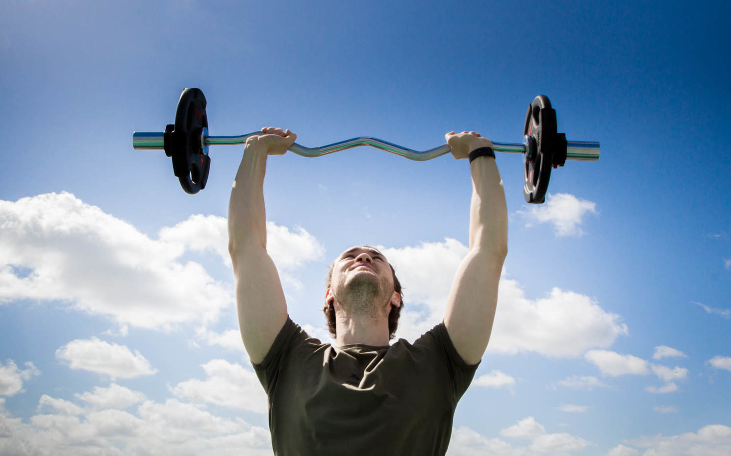 Man holding barbell up into the sky